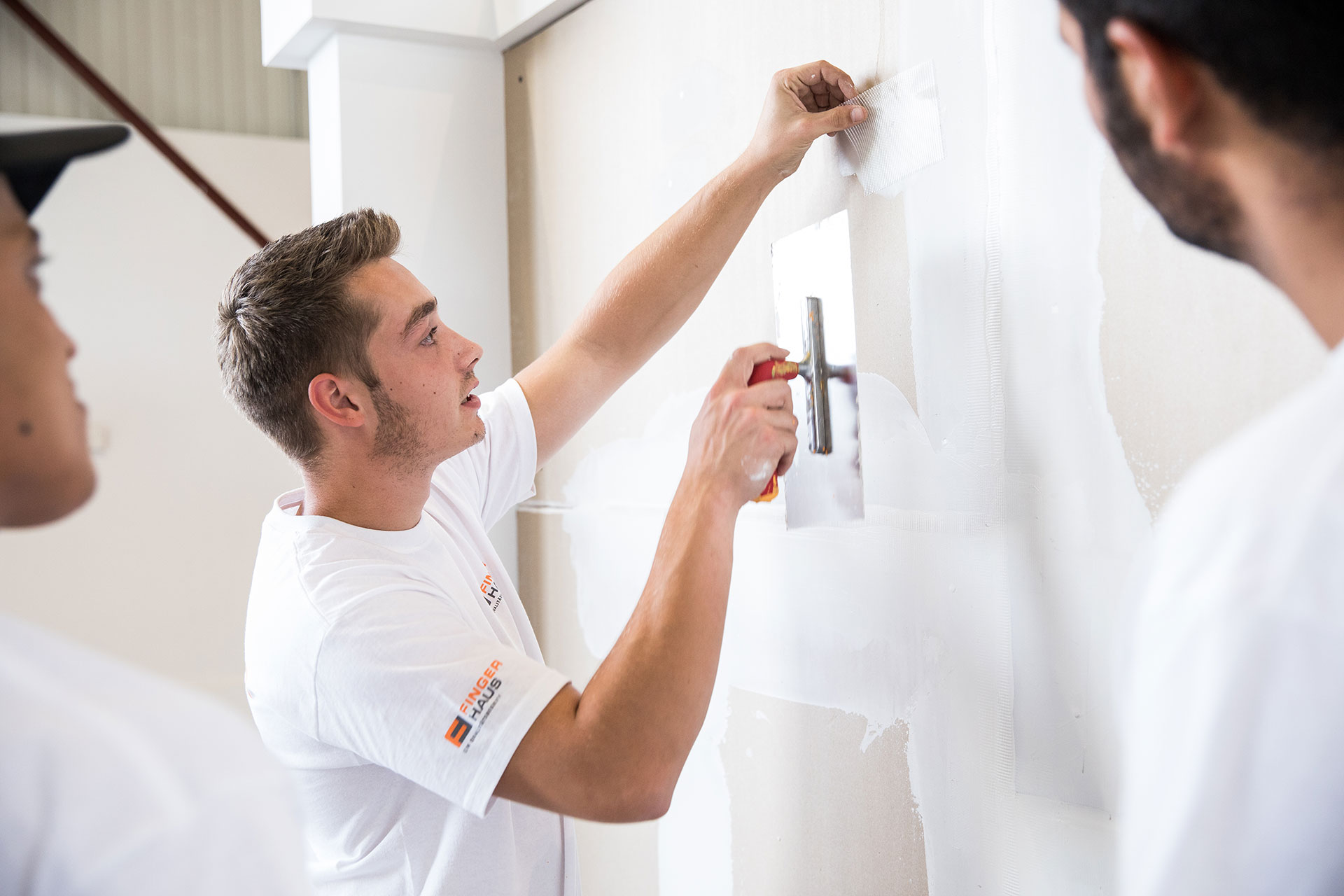 Maler und Lackierer verspachtelt eine Wand