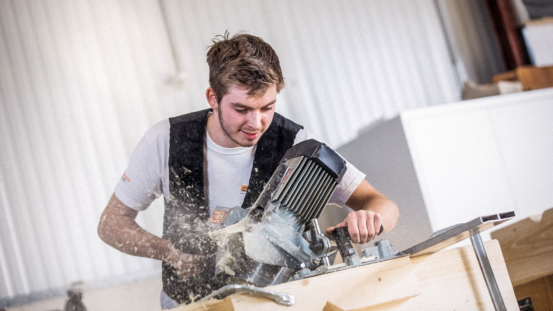 Zimmerer arbeitet mit Kervenfräse auf Holz