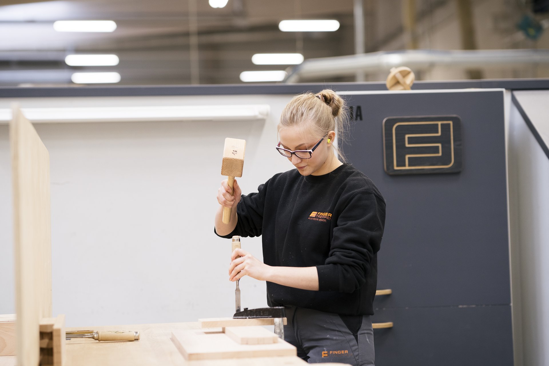 Tischlerin bei FingerTreppen bearbeitet Holz